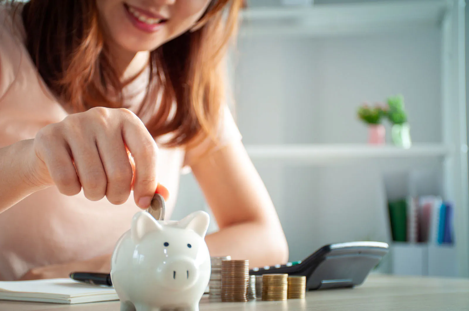 woman putting coins in a bank